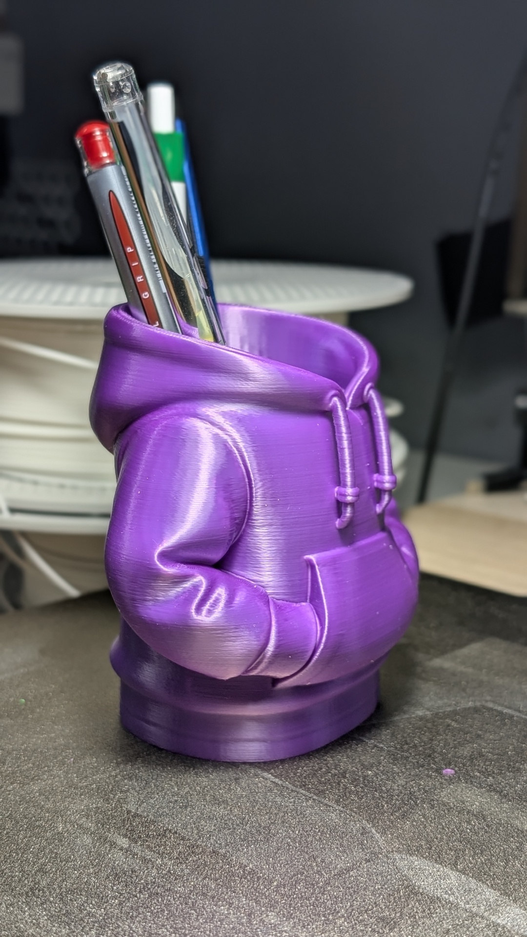 Suporte para canetas roxo em forma de hoodie com canetas dentro