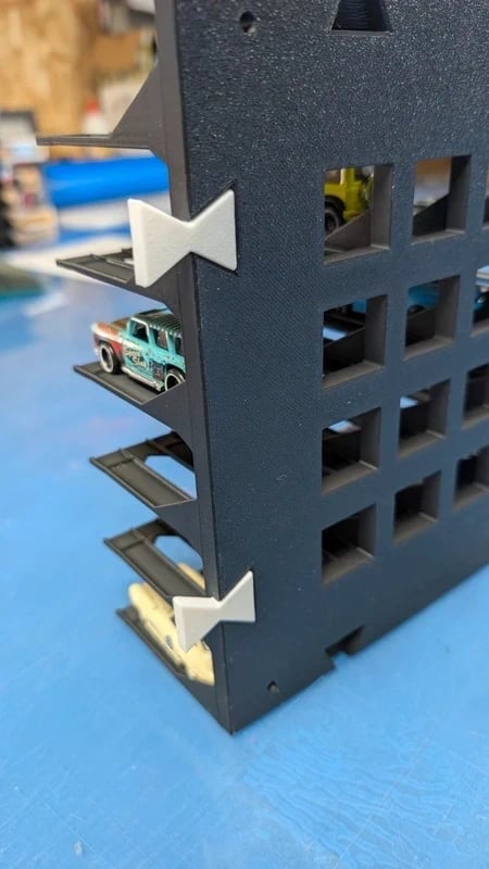 Estrutura preta com carrinhos de brinquedo em miniatura expostos