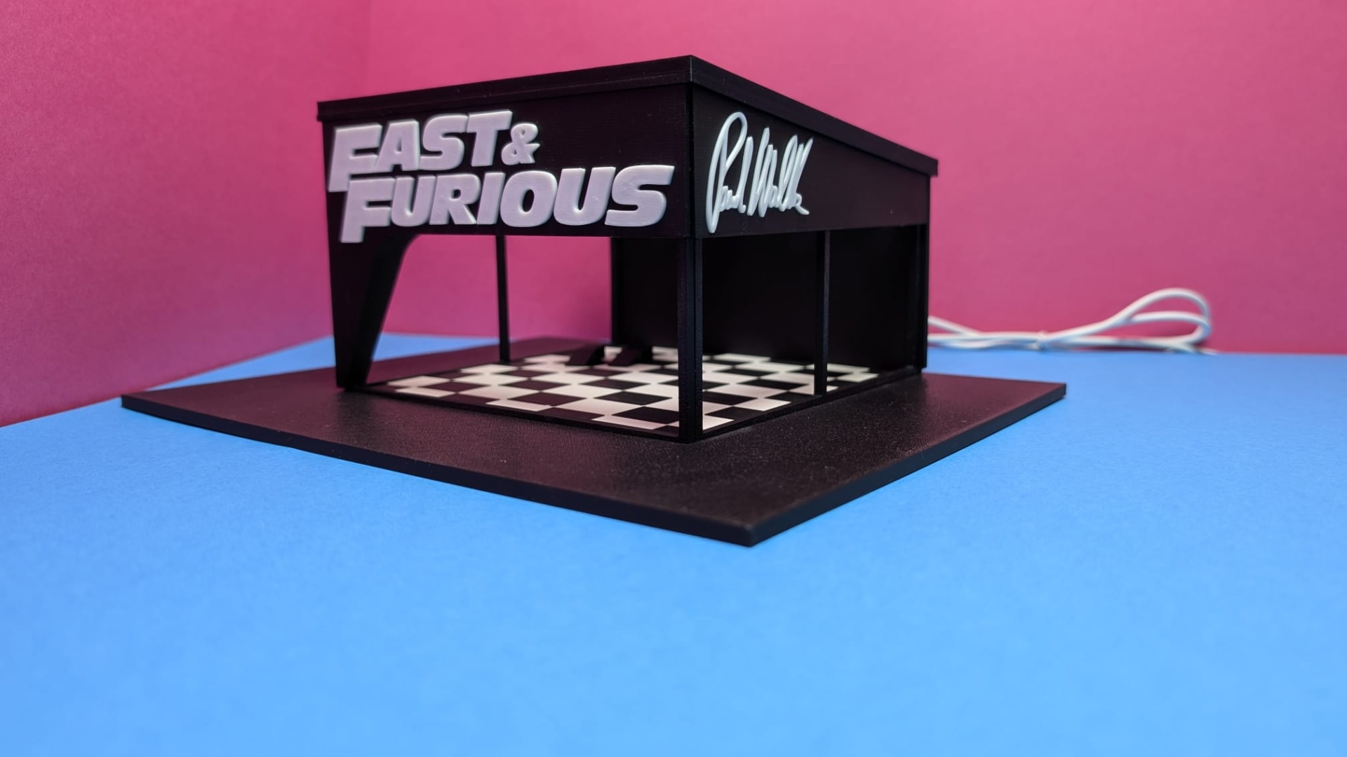 Miniatura preta com chão xadrez e texto FAST & FURIOUS