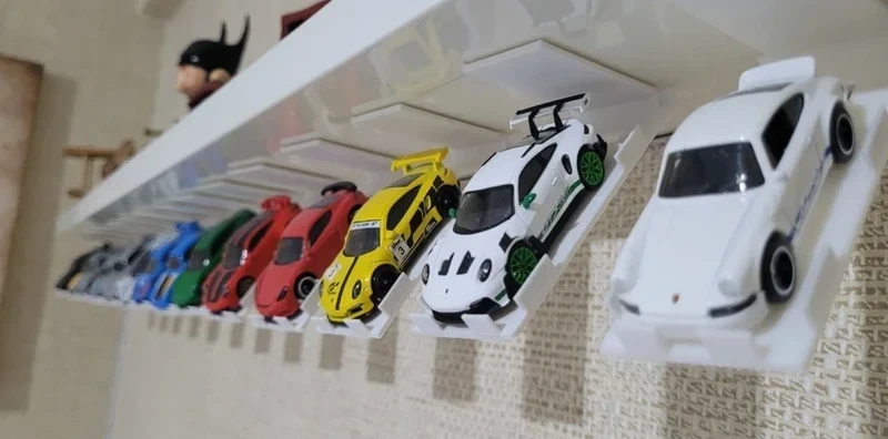 Coleção de carrinhos em miniatura coloridos em suporte branco na parede