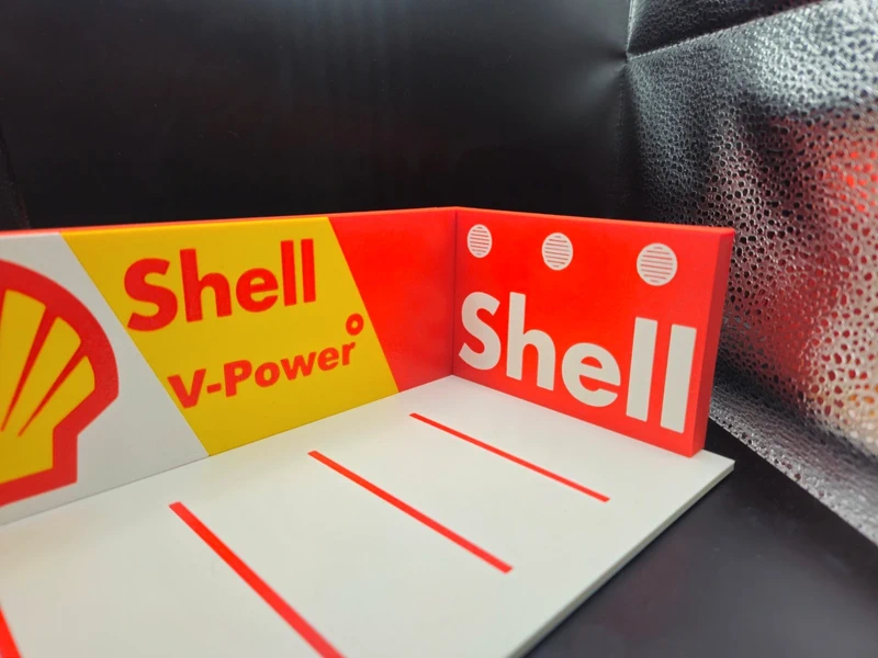 Expositor de cartão Shell V-Power em amarelo, vermelho e branco sobre superfície branca com linhas vermelhas