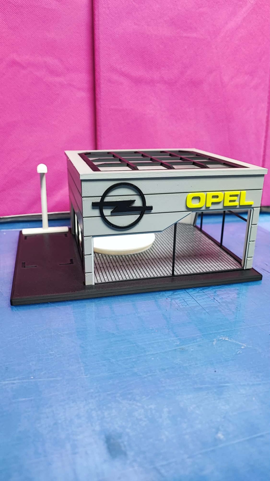 Modelo de edifício com logotipo Opel e texto amarelo