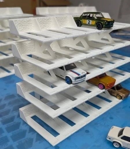 Suporte branco em camadas com carros em miniatura