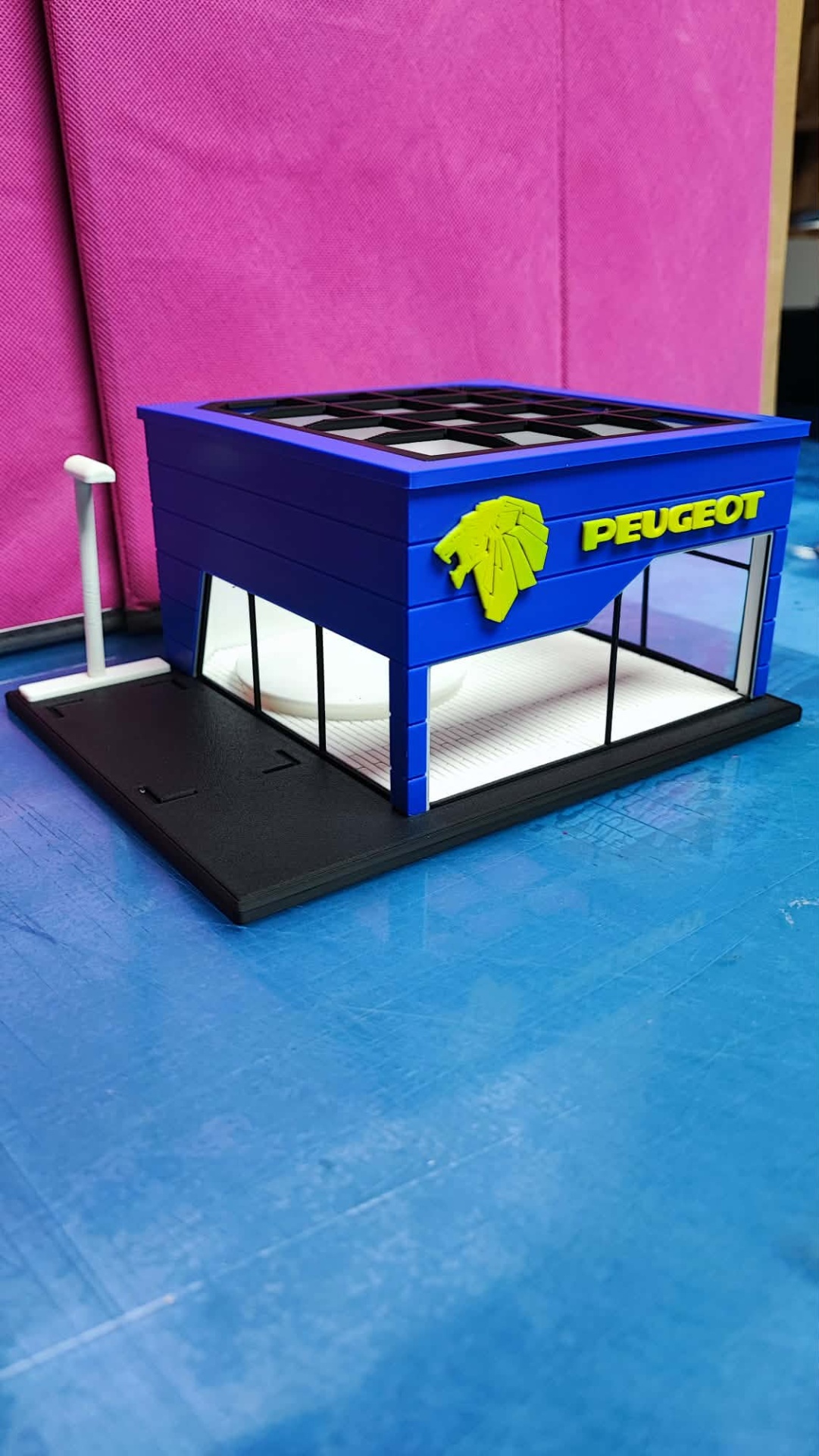 Miniatura de concessionária Peugeot azul com logótipo e texto amarelo