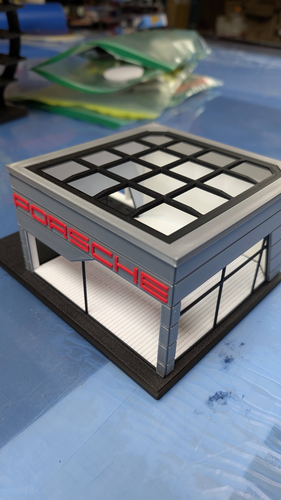 Modelo em miniatura de edifício Porsche cinza com logótipo vermelho