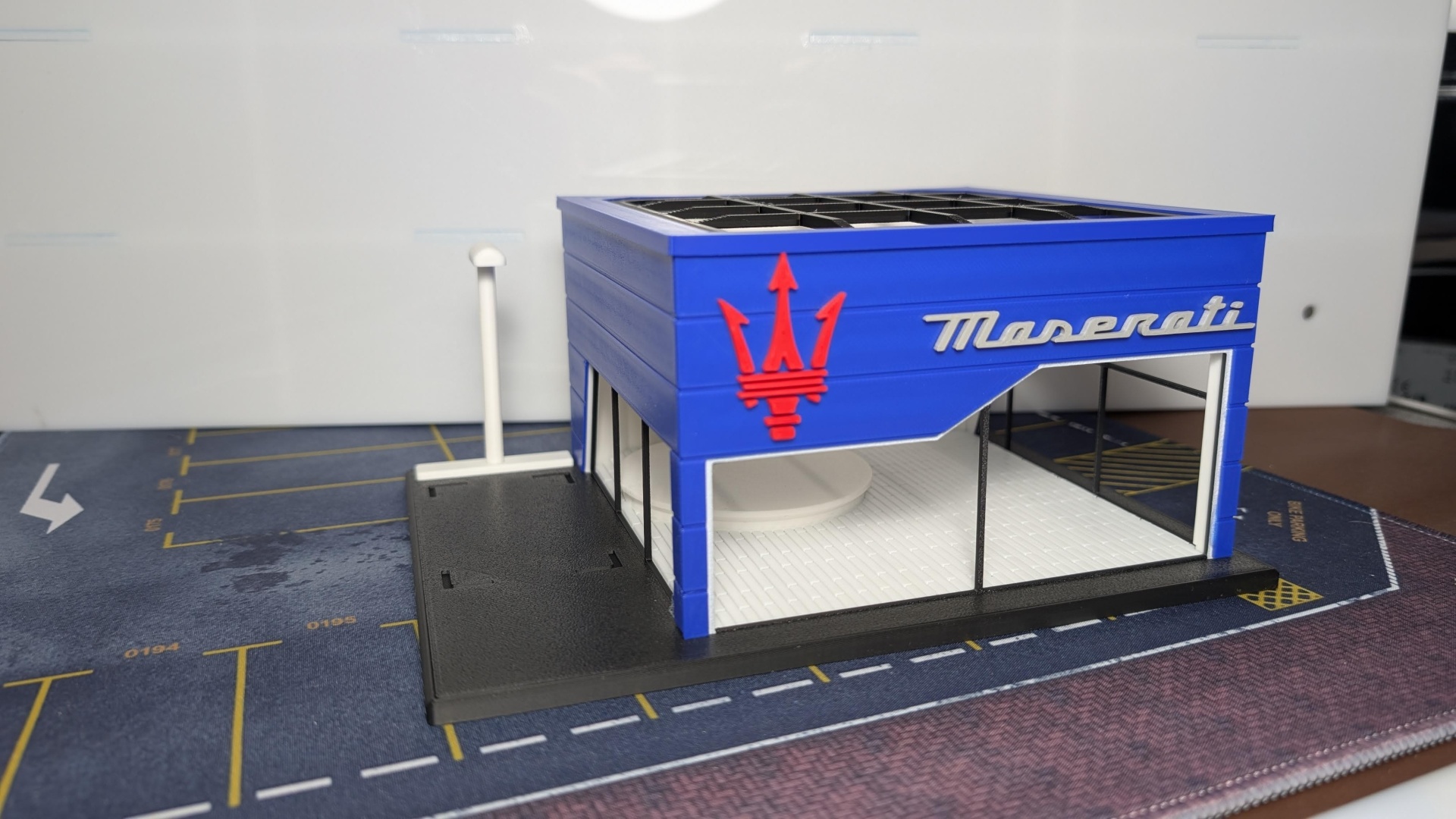 Maqueta de construção azul da Maserati com logo vermelho e texto branco