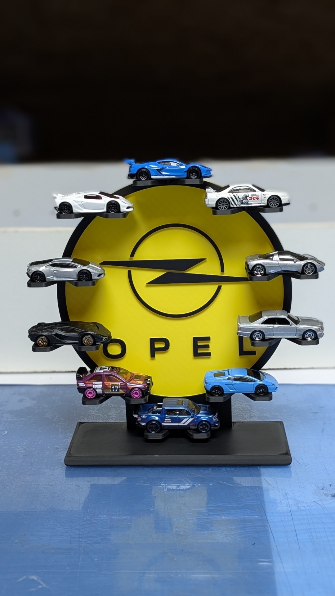 Miniaturas de carros em suporte com logo Opel amarelo