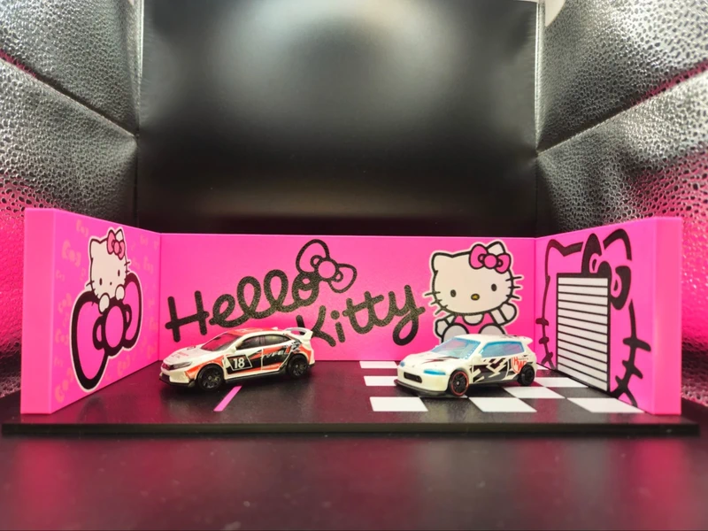 Miniaturas de carros brancos numa base com decoração rosa Hello Kitty