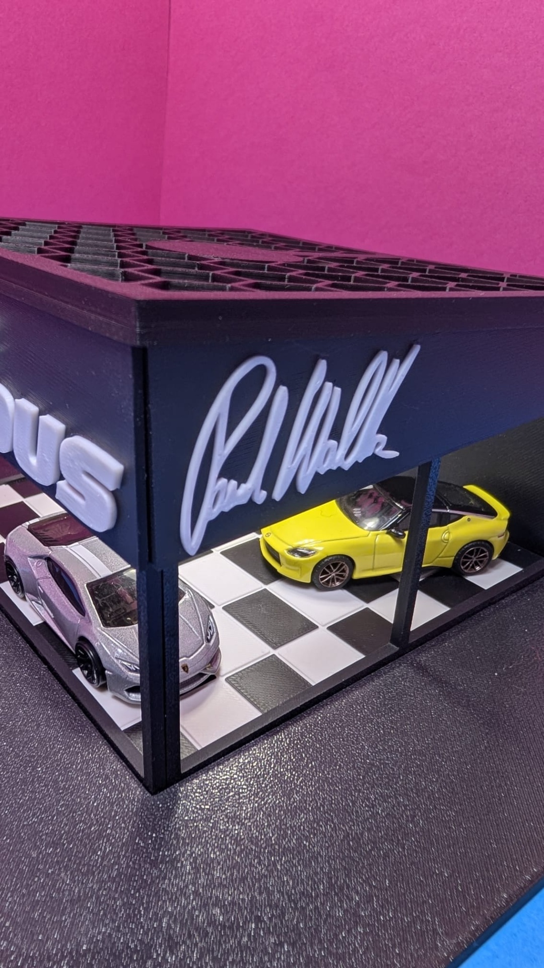 Miniatura de garagem com dois carros e assinatura Paul Walker