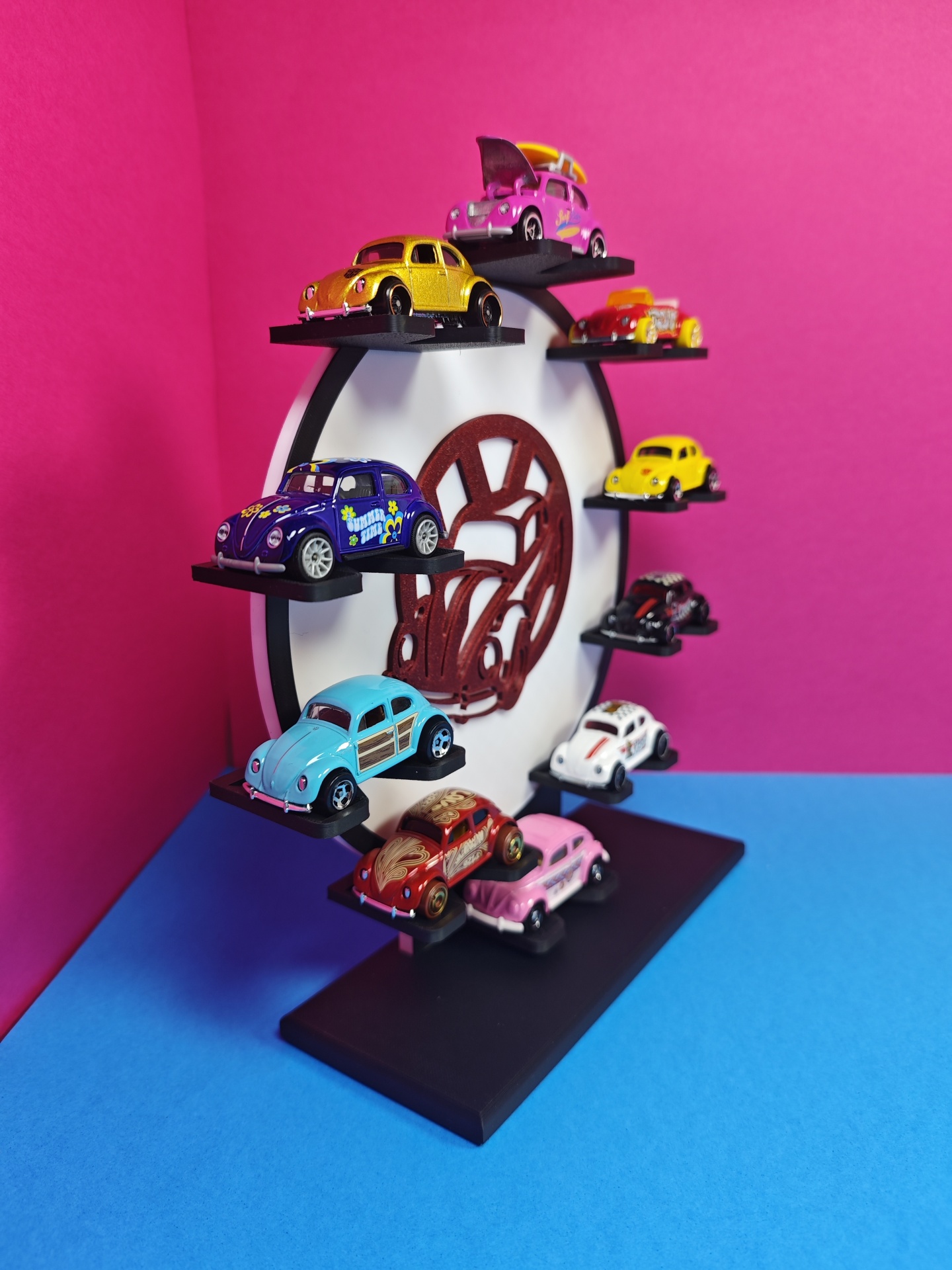 Suporte de exposição com carrinhos de brinquedo Volkswagen Beetle de várias cores.