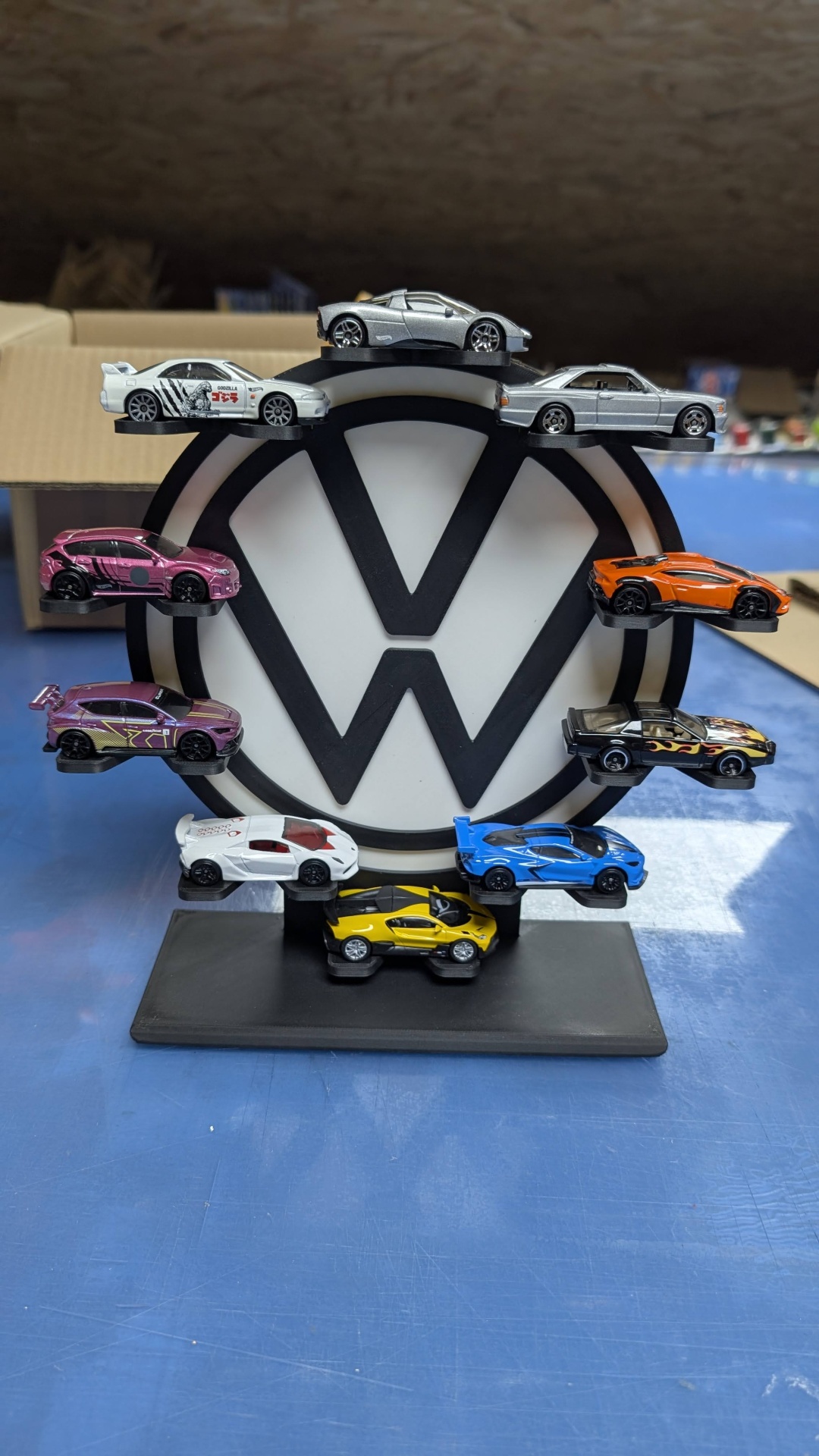 Suporte com miniaturas de carros e logótipo VW