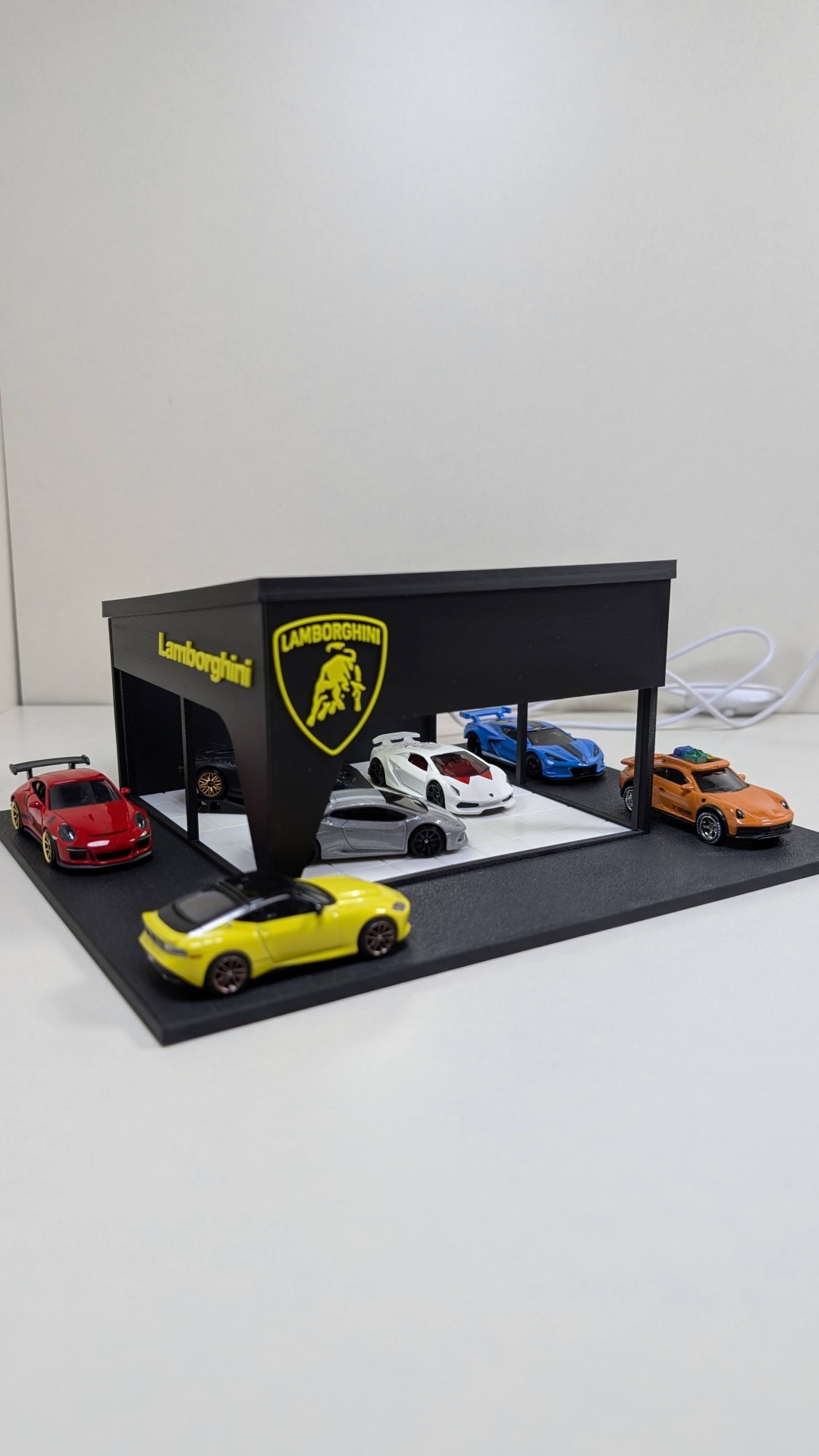 Expositor preto com carros de brinquedo coloridos da Lamborghini