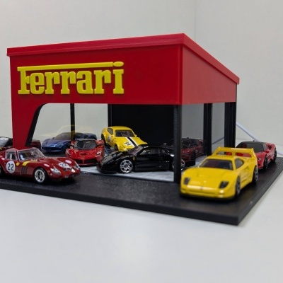 Miniaturas de carros Ferrari exibidas numa base de exposição com estrutura vermelha e logo amarelo Ferrari