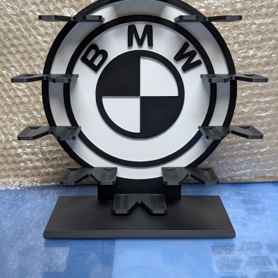 Suporte preto circular com logótipo BMW preto e branco