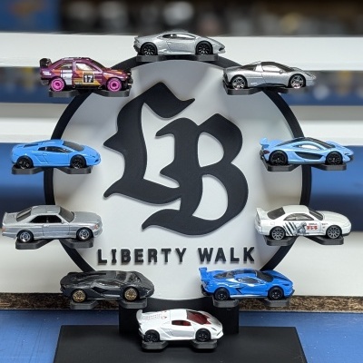Miniaturas de carros exibidas num suporte com logo Liberty Walk