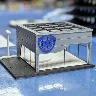 Miniatura de edifício com logótipo azul da LANCIA