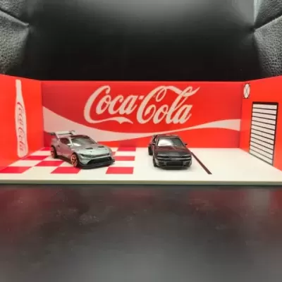Miniatura de cenário com carros e logótipo Coca-Cola