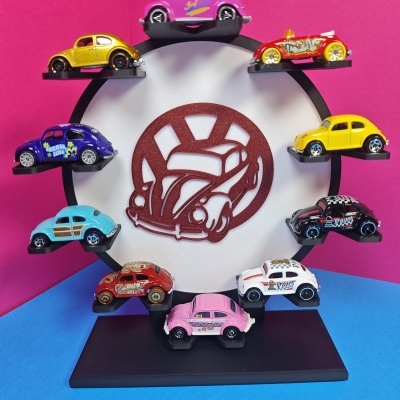 Coleção de carrinhos Volkswagen Beetle coloridos em suporte circular com logo central.