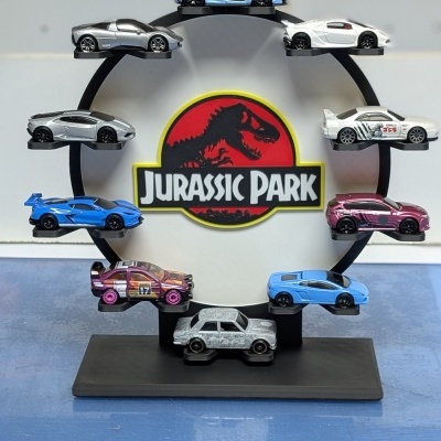 Expositor circular com miniaturas de carros e logótipo Jurassic Park no centro