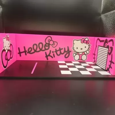 Espaço decorativo rosa e preto com Hello Kitty e padrão de tabuleiro