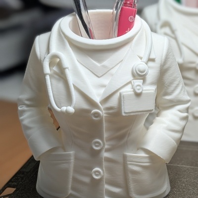 Suporte para canetas em forma de bata médica branca com detalhes de estetoscópio