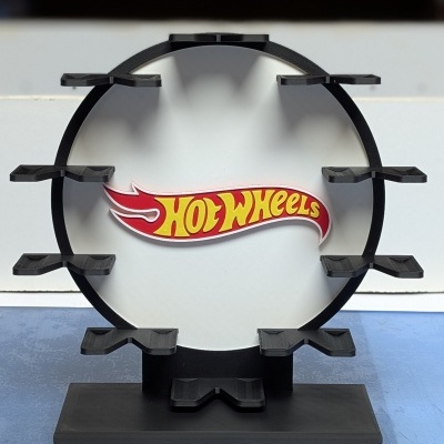 Expositor preto circular para carros Hot Wheels com logo ao centro sobre superfície azul