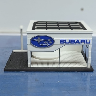 Miniatura de edifício Subaru branco com janelas de vidro e logo azul