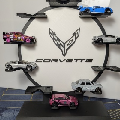 Porta-coleção preto com miniaturas de carros e logotipo Corvette em fundo branco