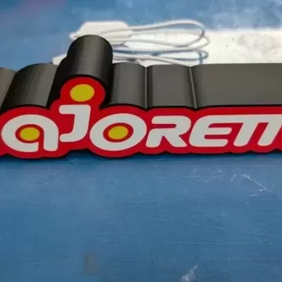 Letreiro decorativo com a palavra majorette em letras brancas e vermelhas sobre fundo preto