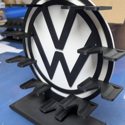 Suporte preto e branco com letras VW e prateleiras retangulares.