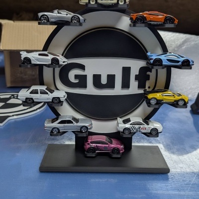 Mini carros coleccionáveis coloridos num suporte com logótipo Gulf
