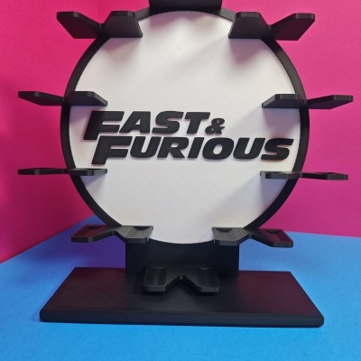 Suporte circular FAST & FURIOUS preto e branco sobre fundo rosa e azul