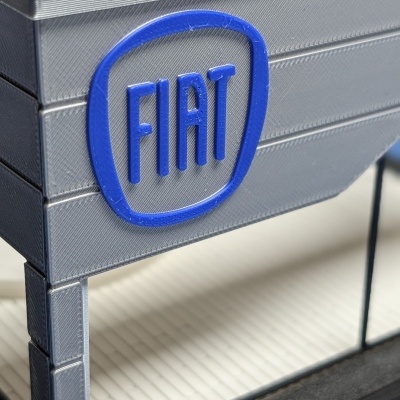 Miniatura cinzenta e preta com logotipo azul FIAT em relevo