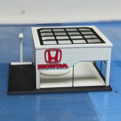 Modelo de loja Honda em miniatura com logotipo vermelho