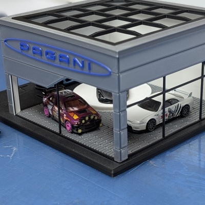 Miniatura de loja de carros com três miniaturas em seu interior