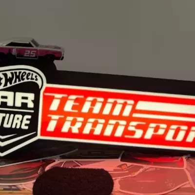 Miniatura de carro Hot Wheels cinzento e rosa com base preta e vermelho com texto