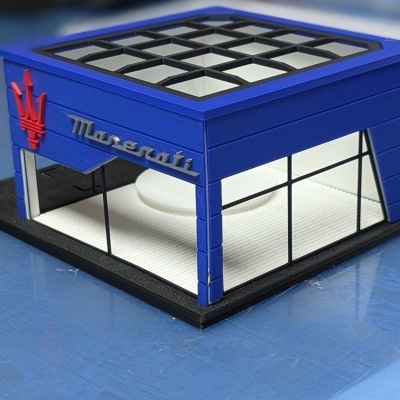 Maquete de loja Maserati azul com janelas e logo vermelho e prateado