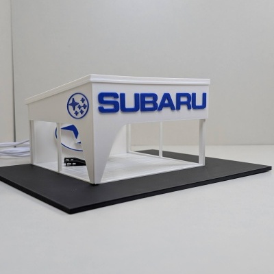 Modelo em miniatura de loja Subaru em branco e azul com base preta