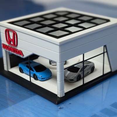 Miniatura de concessionária Honda com dois carros desportivos em exposição