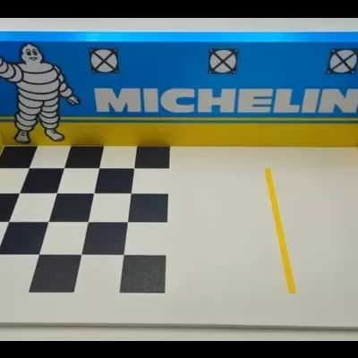 Miniatura de garagem de corrida com decoração Michelin e chão quadriculado