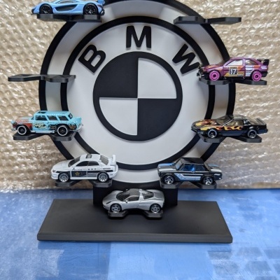 Carrinhos miniatura coloridos em suporte com logotipo BMW