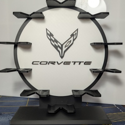 Expositor redondo preto e branco com logotipo e texto Corvette e prateleiras pretas.