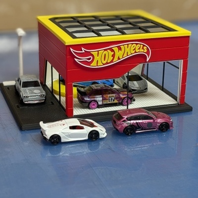 Carrinhos Hot Wheels em cenário com edifício vermelho e amarelo