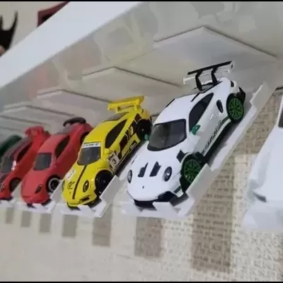 Coleção de carrinhos em miniatura coloridos em suporte branco na parede