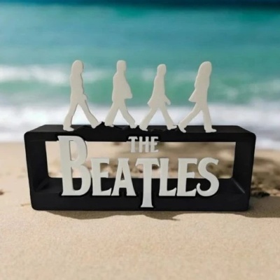 Estatueta decorativa preta com figura branca dos Beatles e texto THE BEATLES
