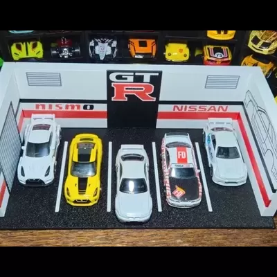 Miniaturas de carros Porsche e Nissan em garagem de exposição pequena