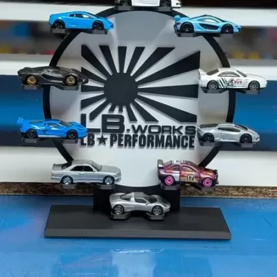 Miniaturas de carros desportivos coloridos em suporte preto com texto de fundo
