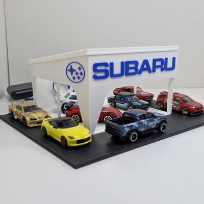 Parque de estacionamento Subaru com miniaturas de carros de coleção coloridos.