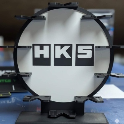 Suporte circular preto e branco com letras H K S e saliências para encaixe