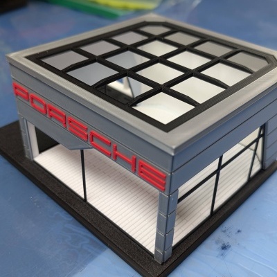 Modelo em miniatura de edifício Porsche cinza com logótipo vermelho